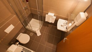 Ein modernes Badezimmer mit einer Duschkabine, einer Toilette und einem Waschbecken.