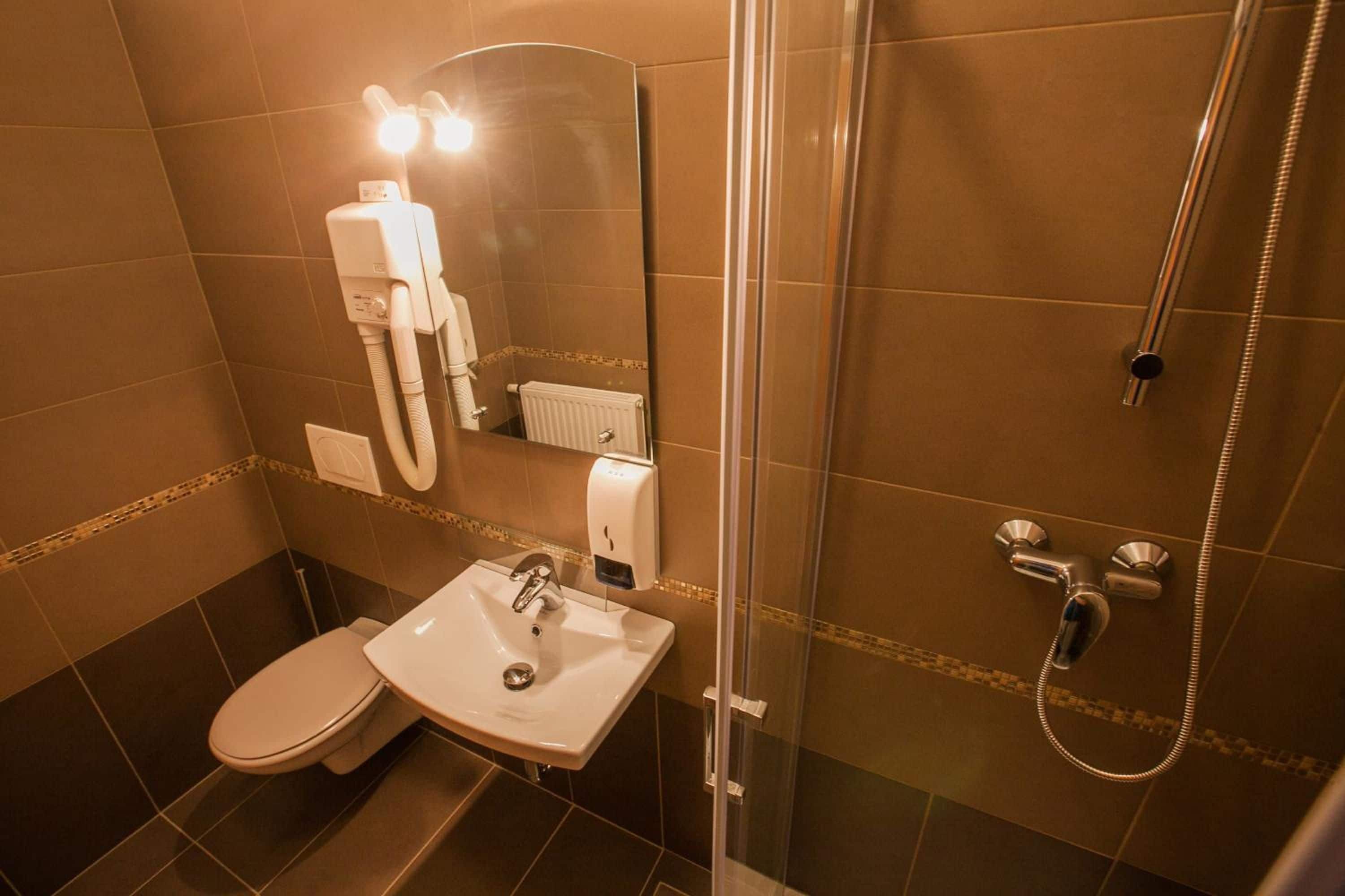 A bathroom with a toilet, sink, and shower.