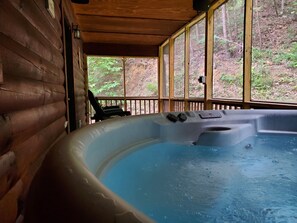 A hot tub in a wooden cabin with a view of a forest. - Your Happily Ever After Starts Here! Private resort cabin near Dollywood!  (Sevierville)