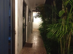 A narrow hallway with tiled flooring and walls, leading to a door. - Comfortable rooms for rent (Mérida)