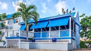 Un bâtiment à deux étages aux couleurs bleu et blanc, doté de grandes fenêtres et d’un balcon.