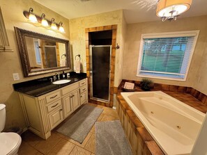 Ein Badezimmer mit großem Spiegel, Waschtisch, Waschbecken und Badewanne.