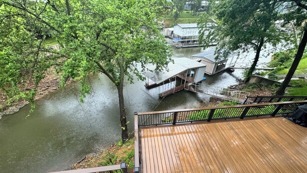 A wooden deck with a view of a river and a dock. - Monkey Island Waterfront with Dock and boat ramp right next to it. (Afton)