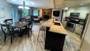A modern kitchen with granite countertops, stainless steel appliances, and a stone backsplash. - Monkey Island Waterfront with Dock and boat ramp right next to it. (Afton)