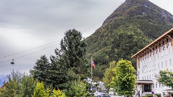 Hotel met uitzicht op een berg, een vlag en een skilift.