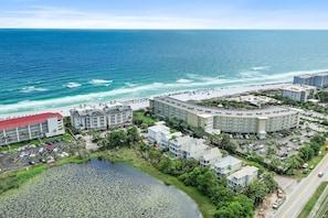 Un hôtel situé sur la côte, composé de plusieurs bâtiments, doté d’un parking et offrant une vue sur la plage.