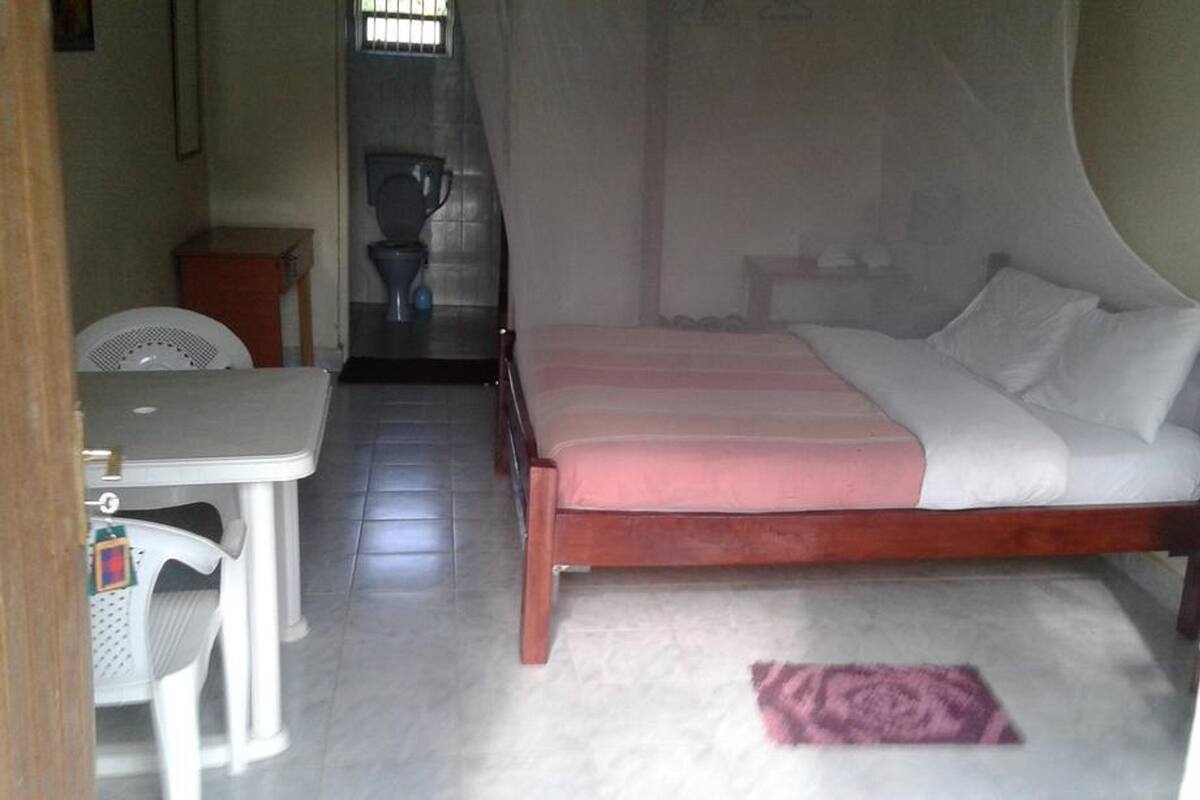 Una habitación pequeña y limpia con una cama, una mesa y una silla.