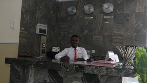 A reception desk with a marble counter, clocks displaying time in London, Lagos, and New York, and a digital clock.