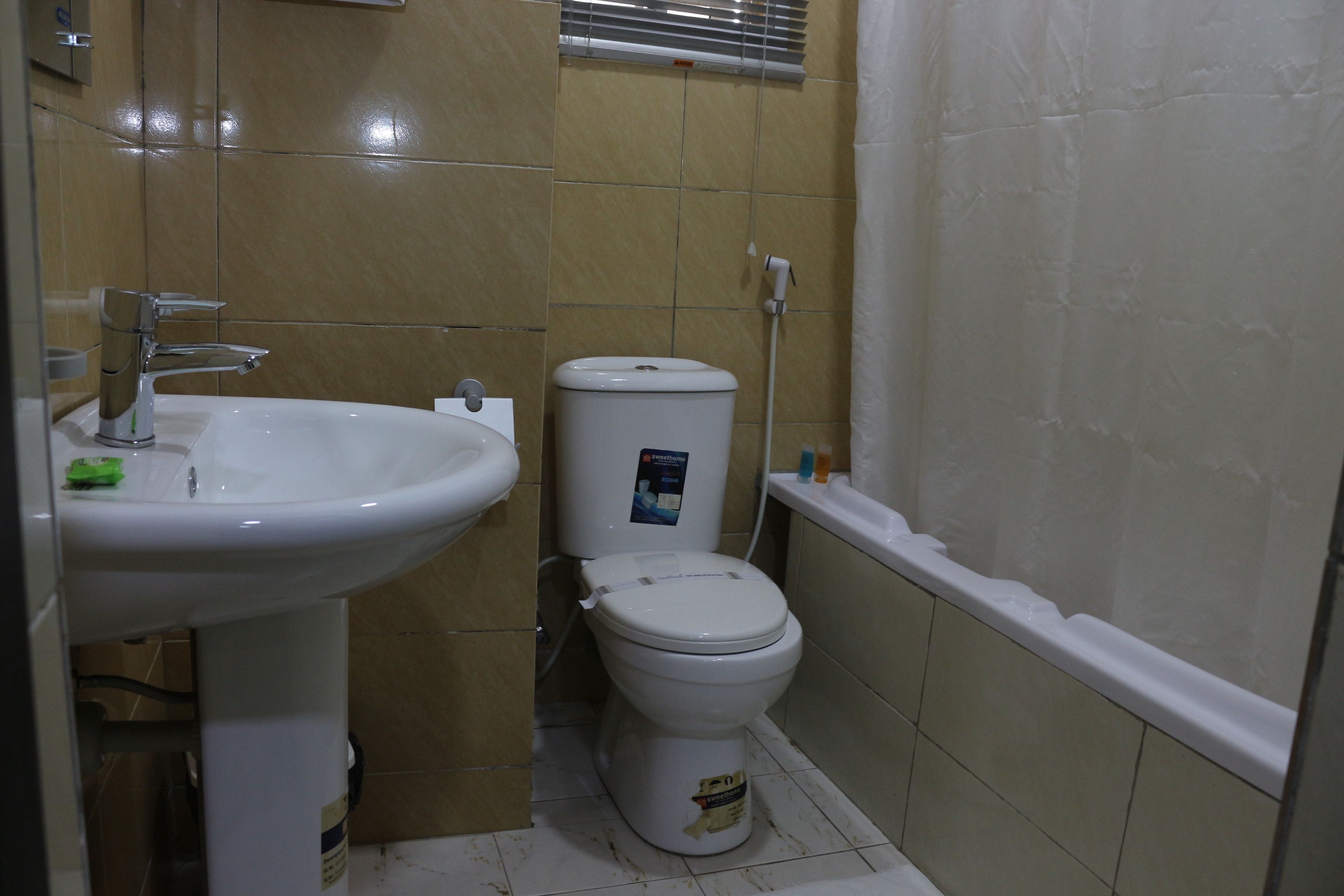Un baño con lavamanos, inodoro y bañera blancos.