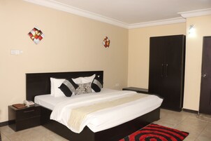 Un dormitorio ordenado con cama, mesitas de noche y un armario.