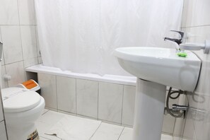 Une salle de bain avec des toilettes, un lavabo et une baignoire.