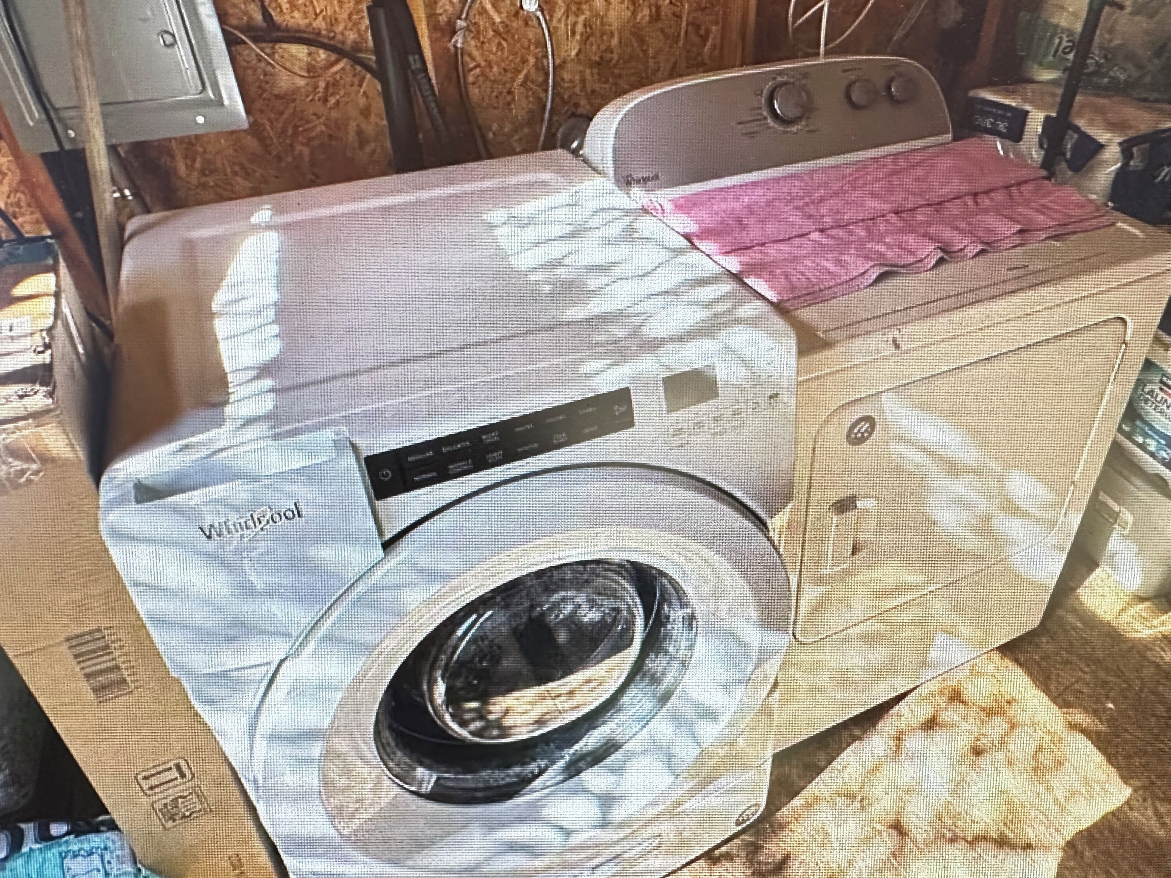 A front-loading washing machine with a front control panel, a dryer, and a pink cloth on top.