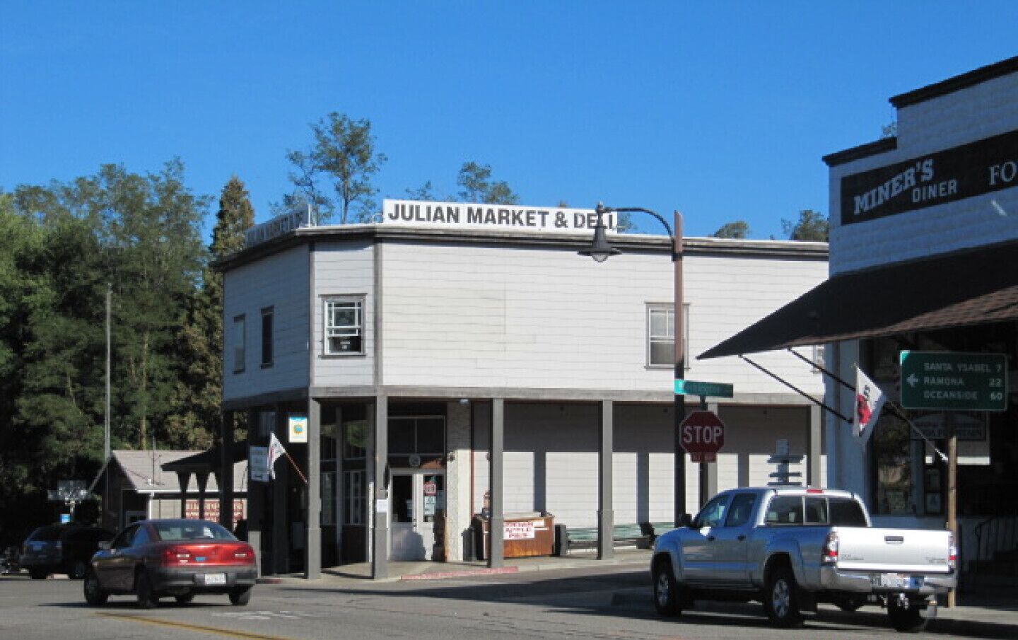 Mercado y deli Julian, con una señal de stop y una cafetería al otro lado de la calle.
