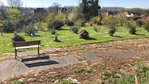 A park with a bench, trees, and a grassy area. - Le Relais du Beffroi (Saint-Riquier)