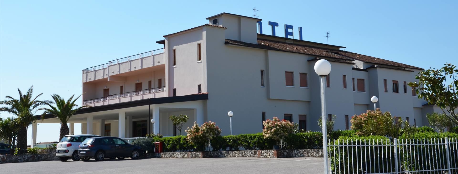 Un hôtel à la structure à deux étages, doté d’un balcon au dernier étage et d’une enseigne indiquant « HÔTEL ».