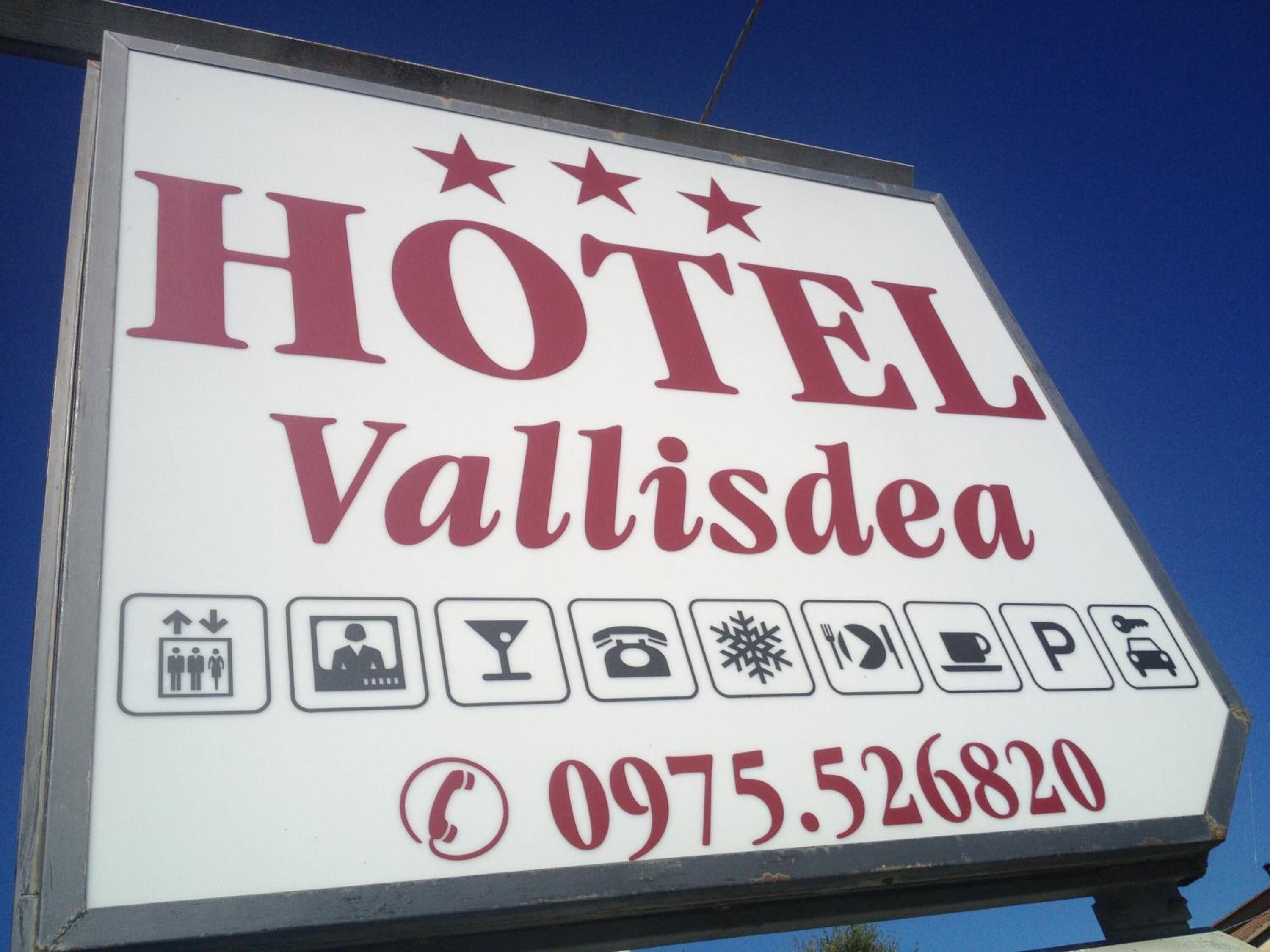 Placa de hotel com o nome 'HOTEL Vallisdea' e o número de telefone '0975.526820'.