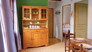 A dining area with a wooden cabinet, a table set for two, and a green wall. - 1 bedroom stunning home in Hames-Boucres (Hames-Boucres)