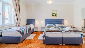 Habitación de hotel con dos camas, piso de madera, un cuadro en la pared y lámparas de noche.