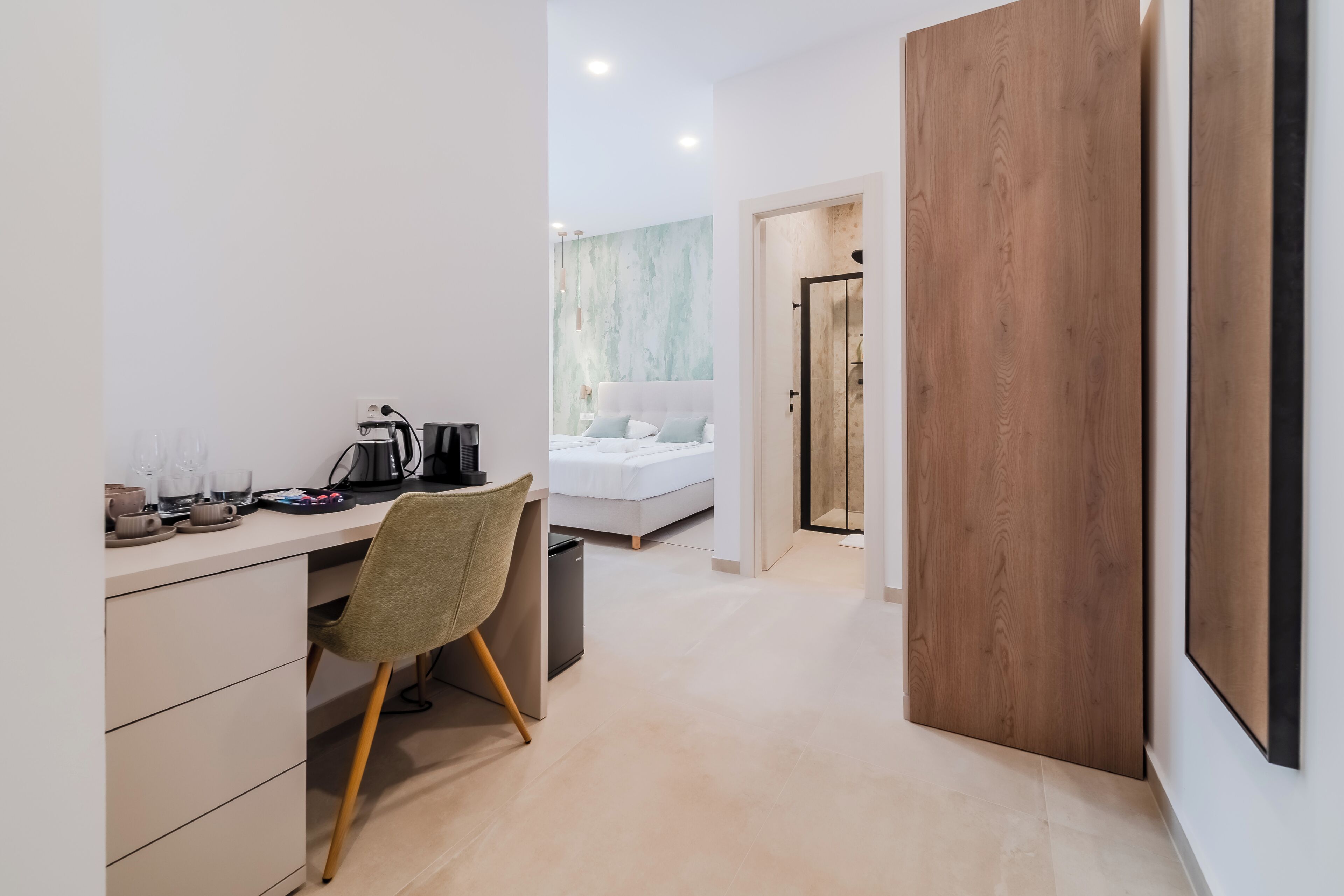 A modern bedroom with a bed, bedside table, and a desk with a chair.