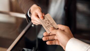 A person handing over a wooden card to another person.