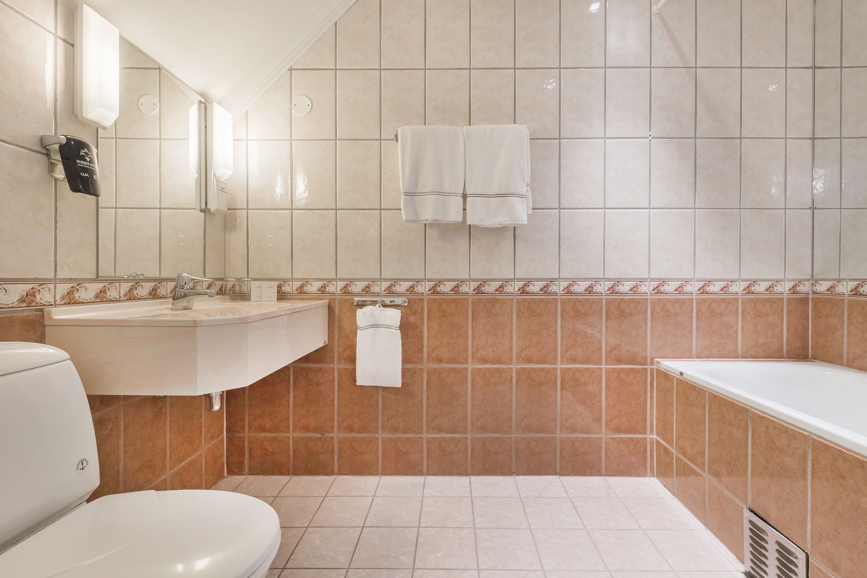 A bathroom with a toilet, sink, and bathtub.