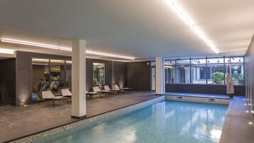 Relax by the pool surrounded by comfortable lounge chairs and a clean, modern design.