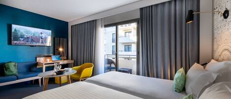 A hotel room with a bed, a desk, a chair, a TV, and a balcony with curtains.