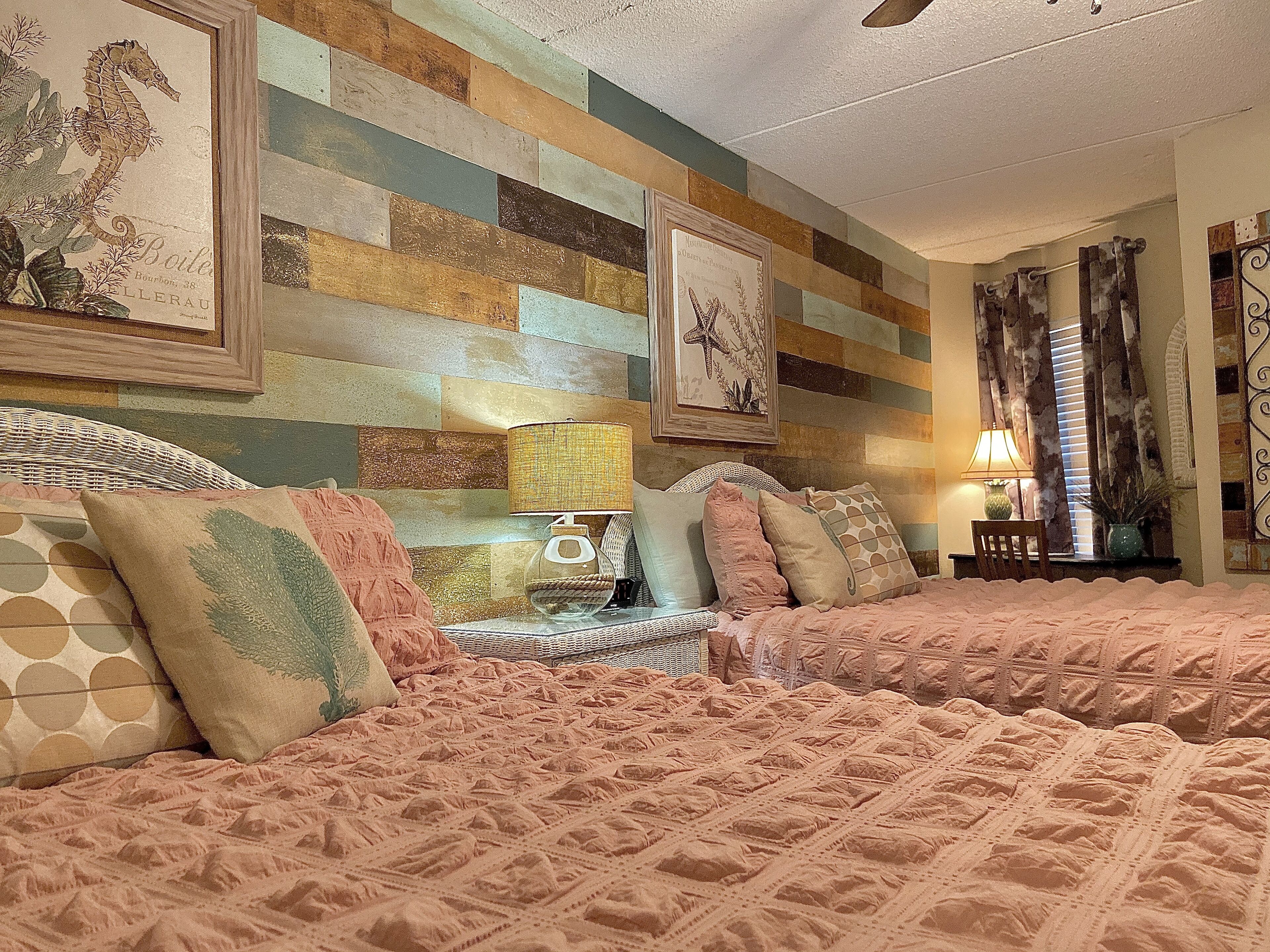 Quarto com cama grande, mesa de cabeceira, luminária e quadro na parede.
