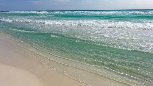 Una playa con agua turquesa cristalina y una orilla arenosa.