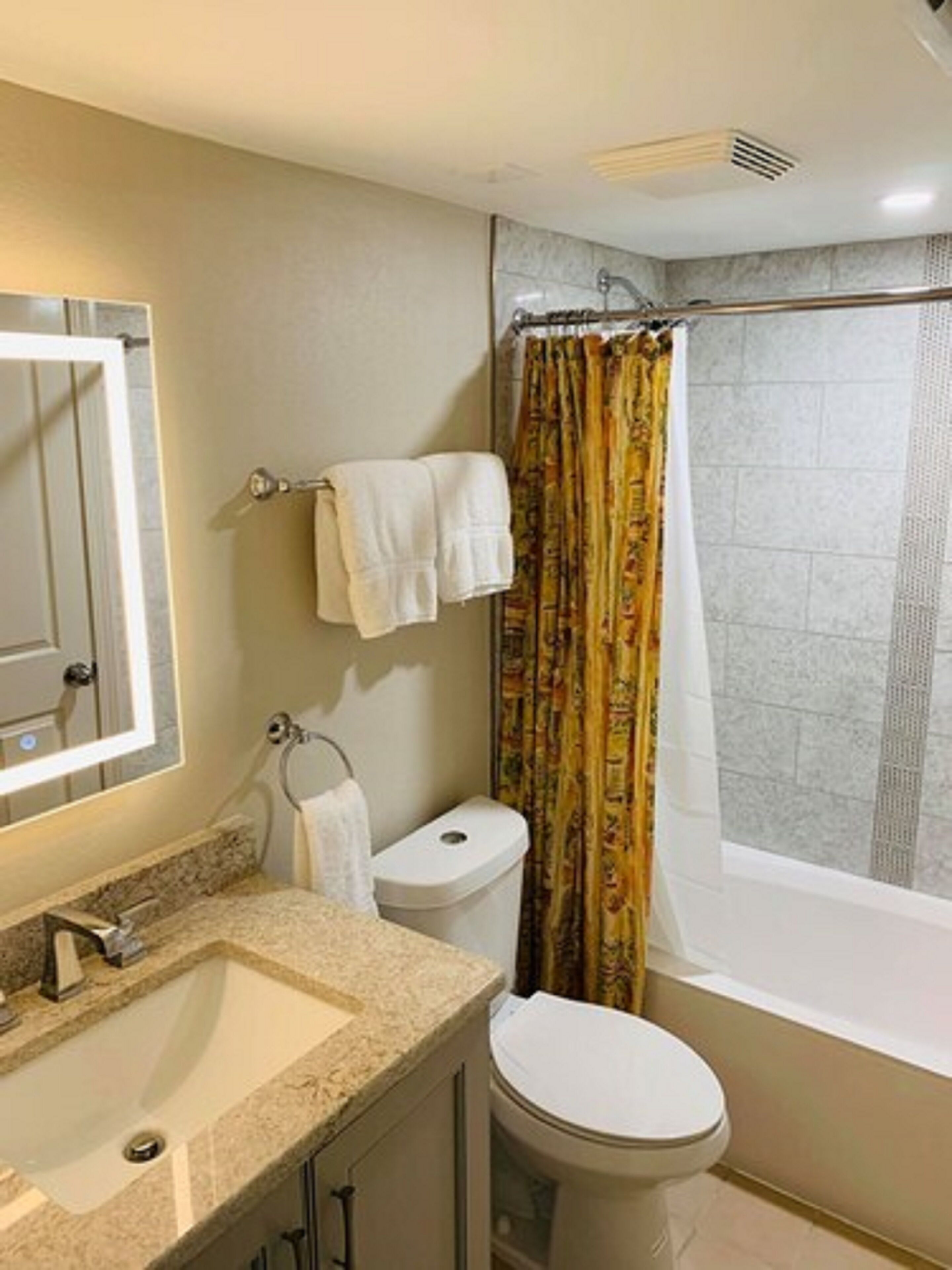 Une salle de bain équipée d’un lavabo, de toilettes et d’un rideau de douche.