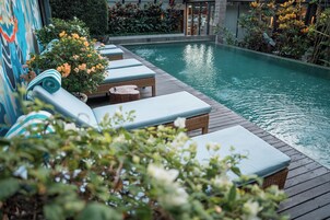 A poolside area with lounge chairs and a wooden deck.