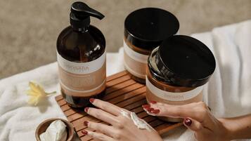 A spa setting with a wooden table, a white towel, and various spa products.