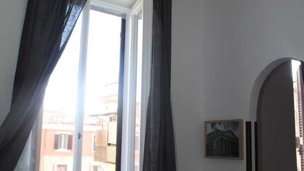 Ein Zimmer mit Fenster, Heizkörper und Pendelleuchte.