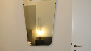 A mirror on a wall, a bench with a book, and a door. - Home2Rome - Trastevere Del Grande (Rome)