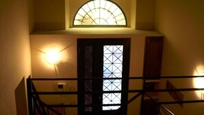 A staircase with a glass door and a light fixture above it.