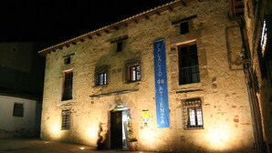 Un edificio de piedra con un letrero que dice "Palacio de Atienza" y la entrada de un hotel.
