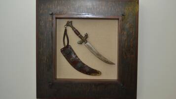 Exhibició emmarcada d'un ganivet i d'una fulla corba amb funda de cuir.