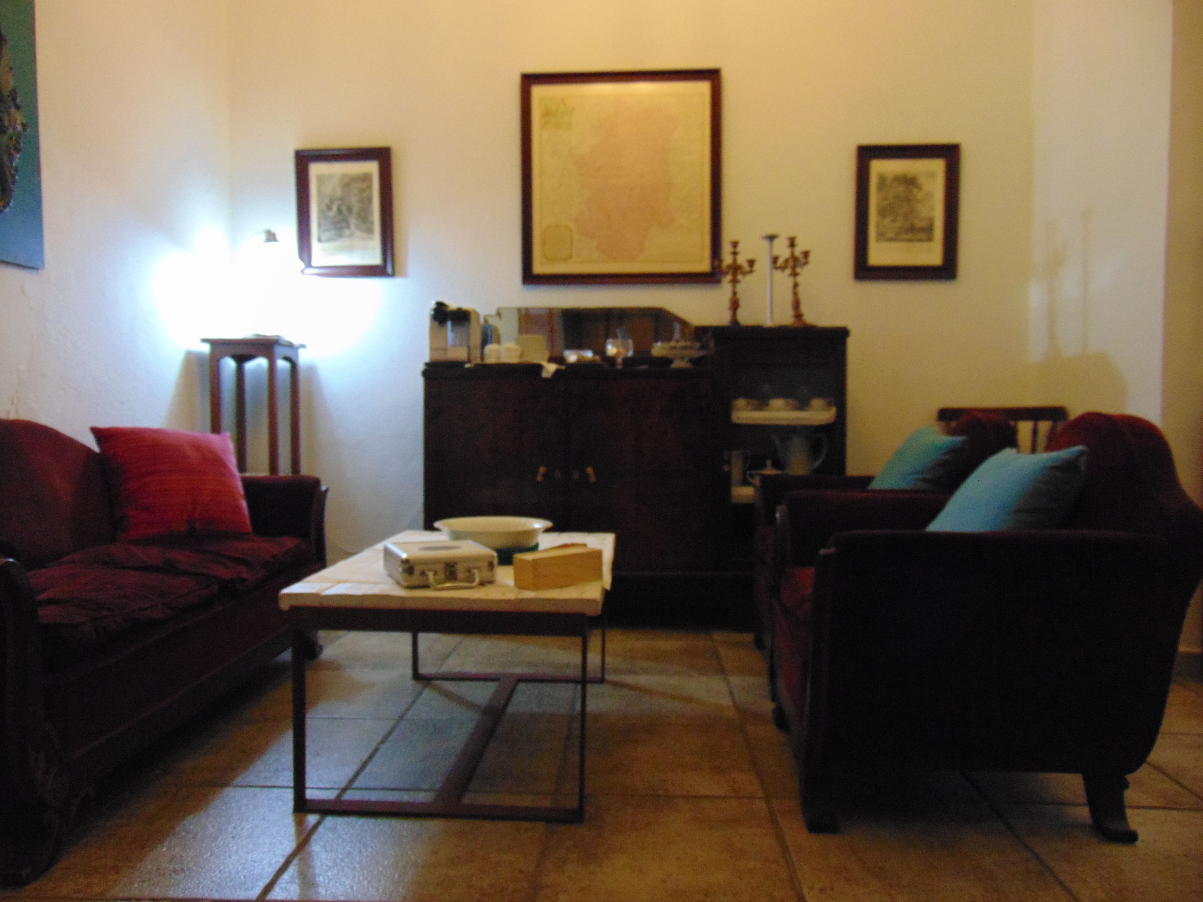 A living room with a sofa, armchair, coffee table, and a cabinet.