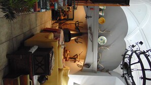 Une pièce avec un plafond haut, un lustre et une grande fenêtre.