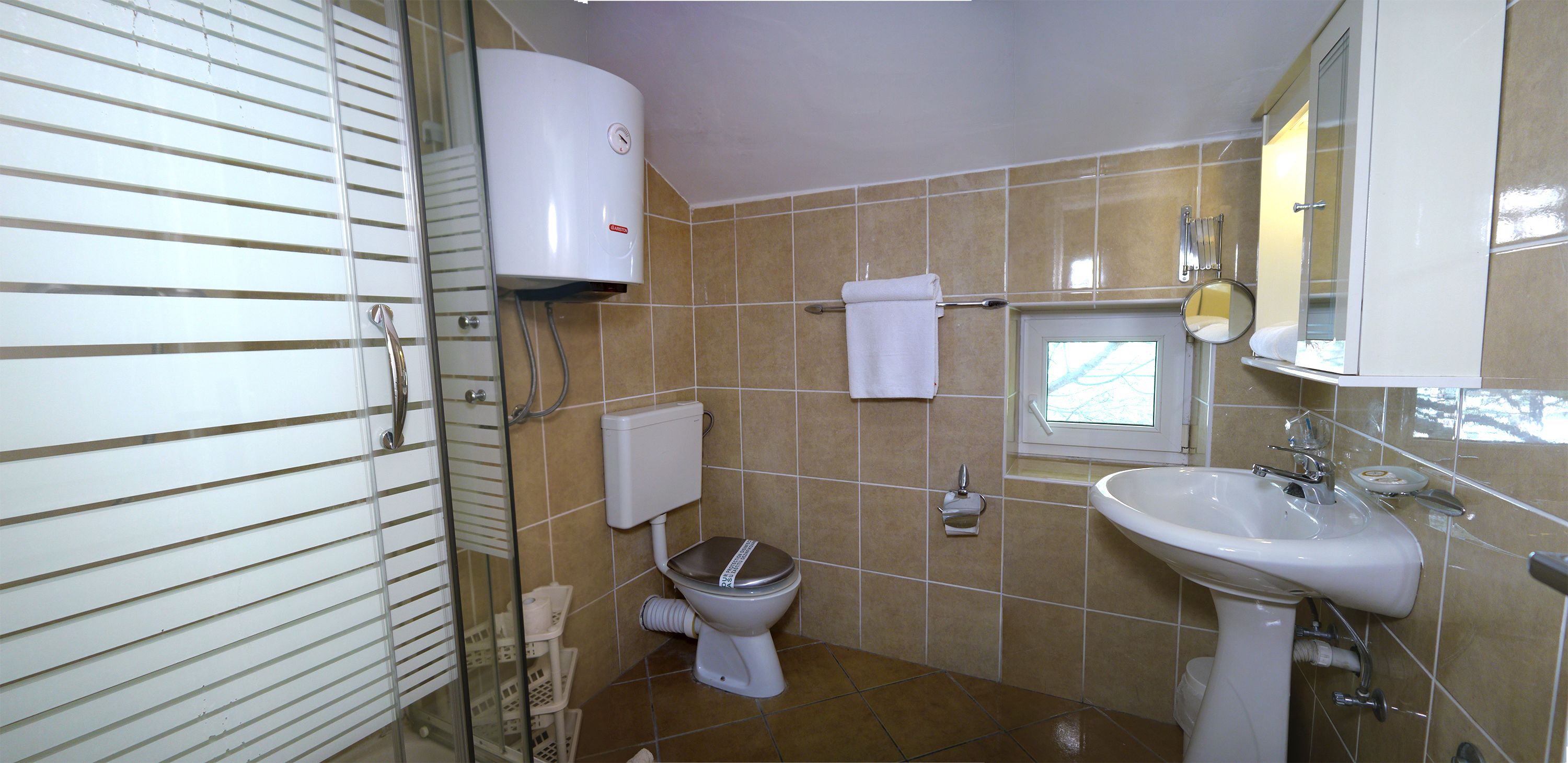 A bathroom with a toilet, sink, and a towel rack.