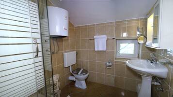 A bathroom with a toilet, sink, and a towel rack.