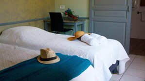 Une chambre d’hôtel avec un lit, une chaise, un bureau et une porte.