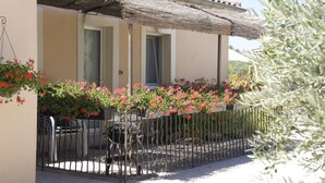 Un immeuble doté d’un balcon, d’une clôture en métal et de jardinières suspendues.