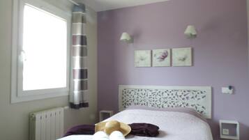 A bedroom with a bed, a window, a radiator, and a ceiling fan.