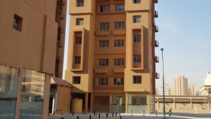 A multi-story residential building with a modern architectural design, featuring balconies and a uniform facade.