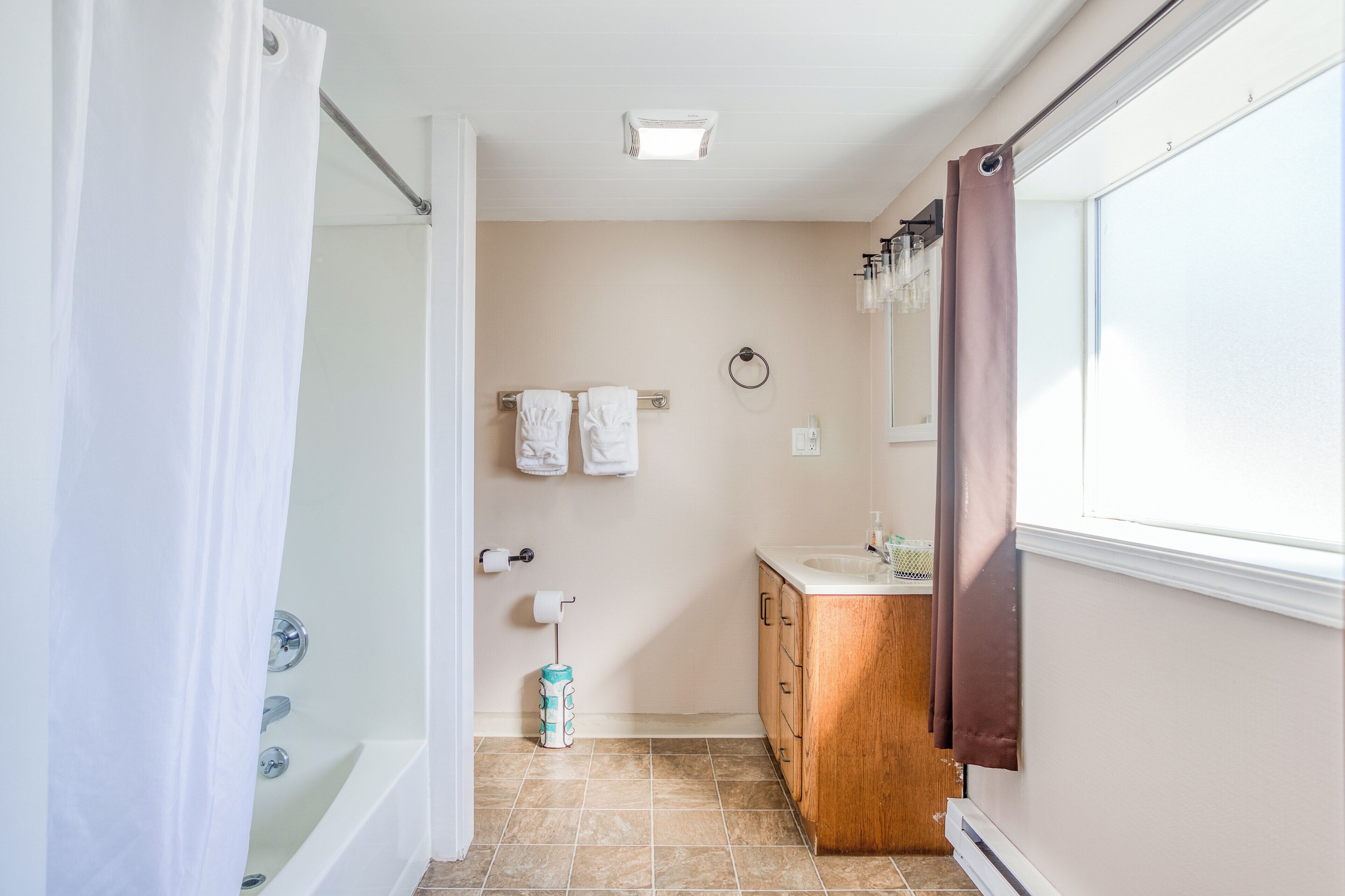 A bathroom with a shower, a sink, and a toilet.