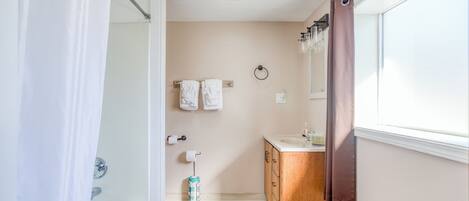 A bathroom with a shower, a sink, and a toilet.