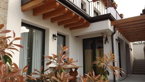 A modern building with wooden balconies, large windows, and potted plants. - Agriturismo Cascina Rossano (Provaglio d'Iseo)