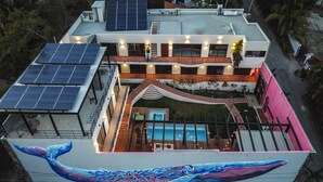 A modern building with a rooftop swimming pool, solar panels, and a large mural of a whale. - Casa de la Ballena (Sayulita)