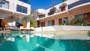 A modern hotel with a clear swimming pool, outdoor seating, and a well-maintained garden. - Casa de la Ballena (Sayulita)